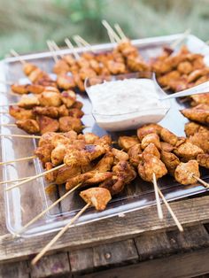 an iphone screenshot of chicken skewers with ranch dressing on the side and tweezers