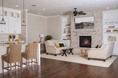 a living room filled with furniture and a fire place in the middle of a kitchen