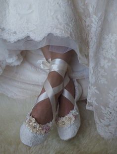 a woman wearing white shoes with sheer stockings on her feet and lace garter around the ankles