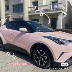 a pink car parked in front of a building