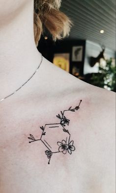 a woman with a tattoo on her chest that has flowers growing out of the back