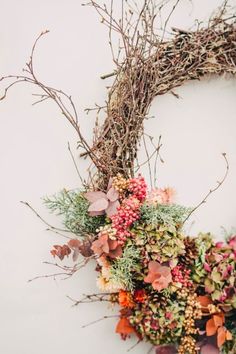 an image of a wreath made out of branches and flowers on a white background with the text send message