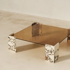 a marble and metal coffee table sitting on top of a white floor