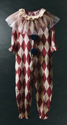 a red and white clown costume hanging on a clothes line with an attached net to it