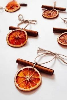 orange slices are tied up with twine and cinnamon sticks to make ornaments for the table