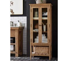 a wooden cabinet sitting next to a sink in a room with black walls and tile flooring