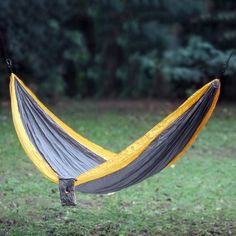 a yellow and gray hammock hanging in the grass