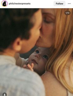 a woman kissing a baby on the cheek