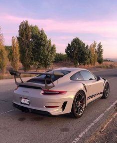 a white sports car parked on the side of the road