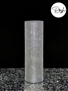 a tall silver vase sitting on top of a table