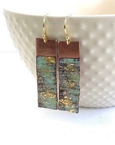 "Seascape Enamel earrings  Textured copper rectangle drop earrings in blue, green and gold. A stunning pair of handmade copper earrings that have  been textured to give the impression of soft rippling waves in the sea.  Inspired by swimming in the open waters around the British Isles.   Rectangle pieces of copper was hammered to give it a rippling texture and then light layers of turquoise and green enamels were fired numerous times to build up the colour and depth.  24ct gold leaf was added to catch the ripples to give the impression of the sun sparkling over the water.   This would make a beautiful gift for someone who loves the open water or treat yourself to something unique and special. Length = 30mm Width  = 15mm 18\" gold plated sterling silver hook wires If you would like it to be Enameled Copper Jewelry, Enamel Techniques, Enamelled Jewellery, Gold Leaf Jewelry, Enameling Jewelry, Abalone Jewelry, Light Layers, Copper Jewellery, Blue Green Gold