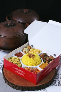 a red box filled with lots of different types of food on top of a table