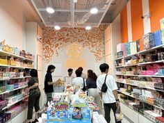 several people standing in a store looking at items on the shelves and talking to each other