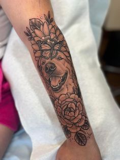 a woman's arm with a dog and flowers on it