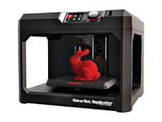 a red stuffed animal sitting on top of a black 3d printer