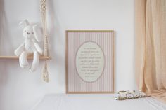 a white teddy bear sitting on top of a bed next to a wooden frame with a poem