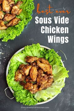 two plates filled with chicken wings and lettuce on top of a black table