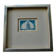 a blue and white drawing in a silver frame