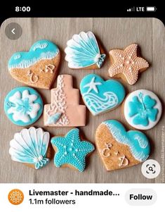 decorated cookies arranged in the shape of hearts, seashells and starfish on a table