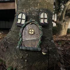 a tree trunk with a house shaped like a door and window on it's side