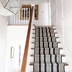 the stairs in this house are decorated with black and white striped rugs on them