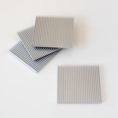 four gray and white striped coasters sitting next to each other on top of a table