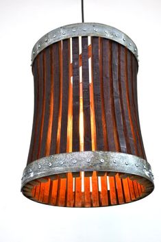 a wooden lamp hanging from the ceiling with an iron frame and wood strips on it