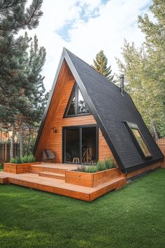 a wooden house with a pitched roof and stairs leading up to the front door, surrounded by lush green grass