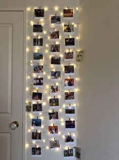 a white door with pictures hanging on it and lights strung from the wall behind them