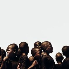 a group of young men standing next to each other in front of a white sky