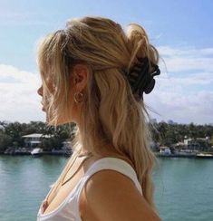 a woman standing on top of a boat looking at the water