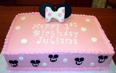 a pink birthday cake decorated with minnie mouse ears