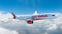 an air india plane flying in the sky above clouds and land area with blue skies