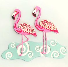 two pink flamingos standing next to each other