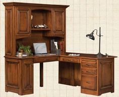 an office desk with wooden cabinets and drawers