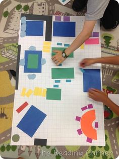 two children are playing with construction paper on the floor