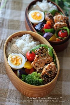 two wooden bowls filled with different types of vegetables and meat on top of white rice