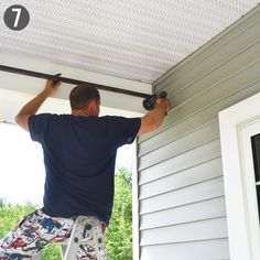 a man is painting the outside of a house