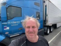 a man standing in front of a semi truck