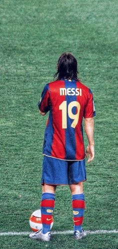 a man standing on top of a soccer field holding a soccer ball in his hand