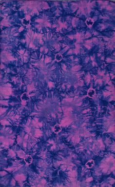 purple and blue tie dyed fabric with small flowers on the bottom, in an abstract pattern