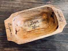 a wooden bowl that has writing on it and is sitting on top of a table