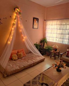 a room with a bed and some lights on the wall next to a table in front of a window