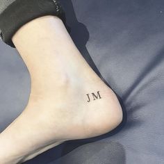 a woman's foot with the word m tattooed on her lower leg and ankle