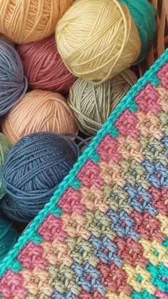 several balls of yarn sitting in a basket next to each other on top of a table