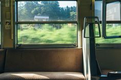 the inside of a train car with windows looking out at grass and houses in the distance