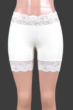 Mannequin wearing organic cotton spandex white stretch lace shorts. Shorts are low rise with approximately 5 inch inseam. Shorts have 2.5 to 3" wide scalloped stretch lace waistband and leg trim. White Stretch Shorts With Short Inseam, White Stretch Lace Shorts, White Lace Loungewear Bottoms, White Elastic Short Bottoms, Fitted Lace Shorts, Stretch Lace Bottoms In Short Length, Stretch Lace Bottoms With Short Length, Stretch Lace Trim Shorts, Stretch Shorts With Lace Trim