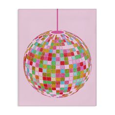 a colorful ball hanging from a string on a pink background