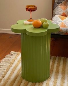 a green table sitting on top of a rug next to a chair