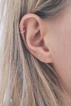 a close up of a person's ear with two small piercings on it